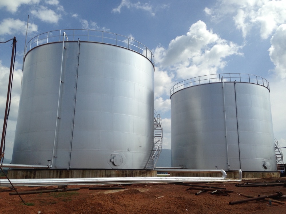 Row of silver storage tanks at a tank farm